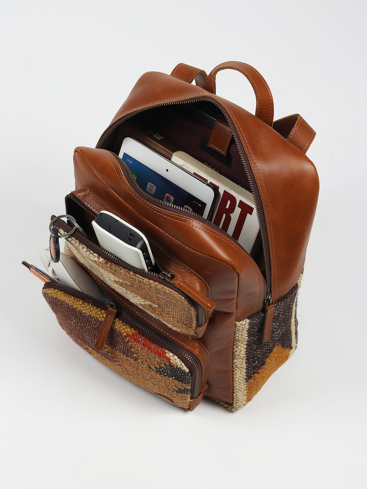 Sabre kilim and leather backpack flat lay — Art Avenue