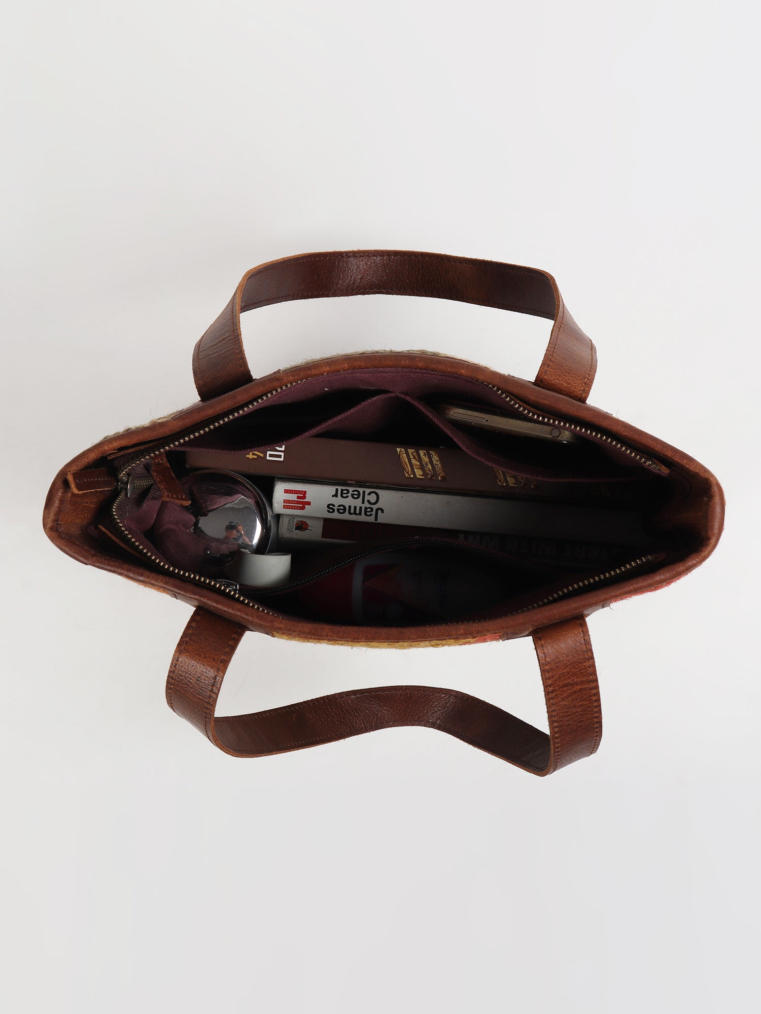 Camelia kilim and leather handbag flat lay — Art Avenue