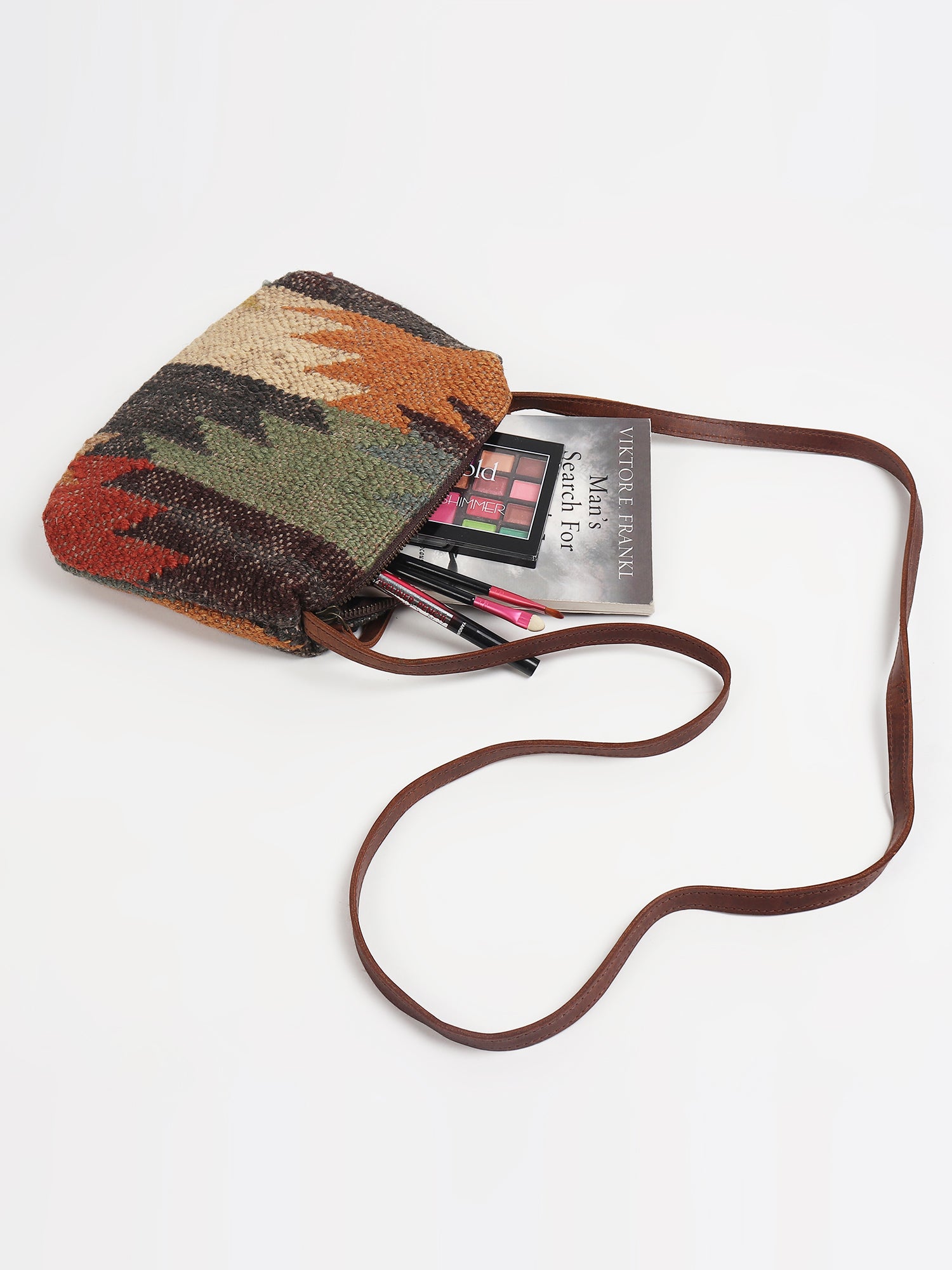 Alpha kilim and leather sling bag flat lay — Art Avenue