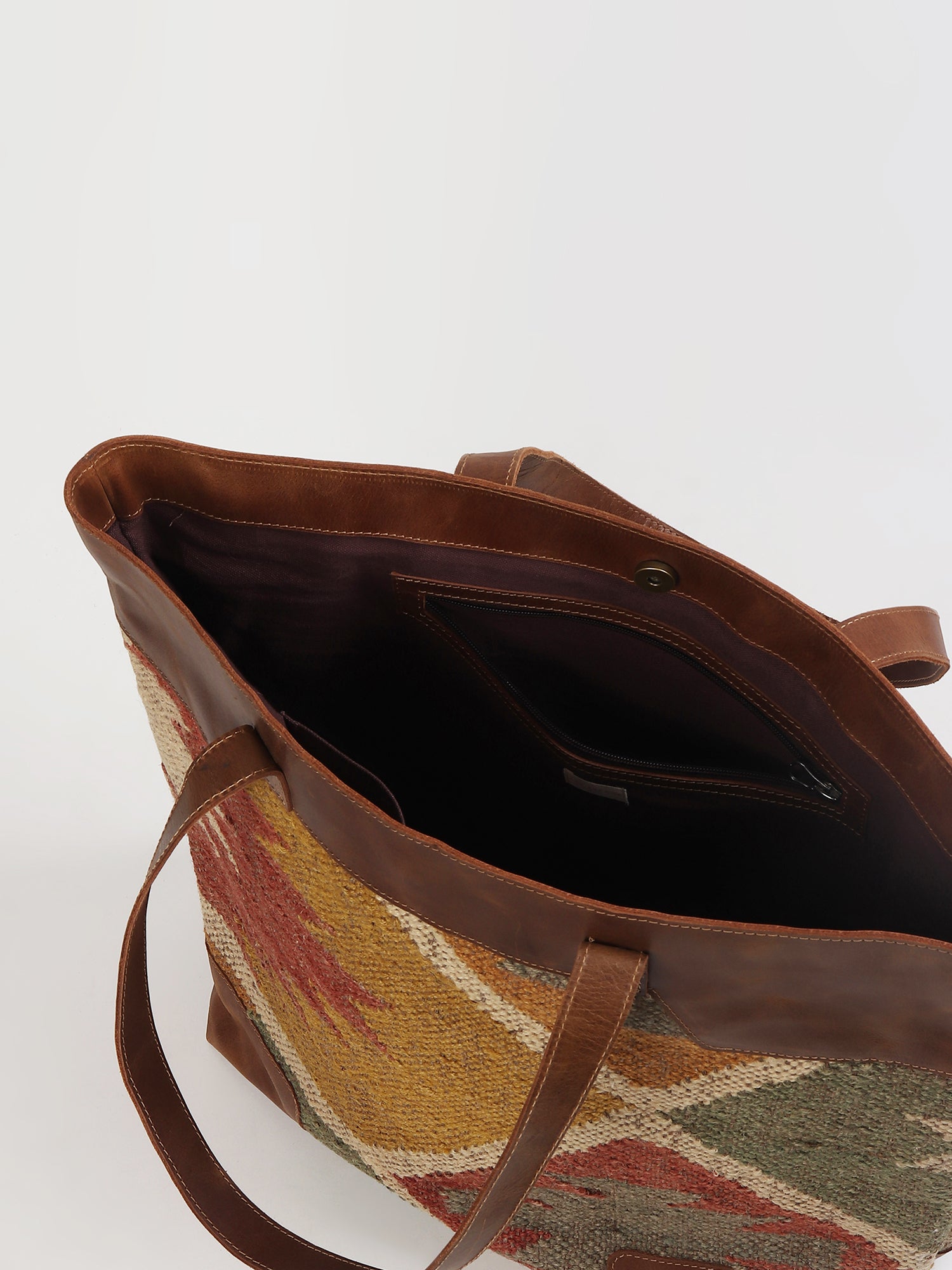 Nahua kilim and leather handbag flat lay — Art Avenue