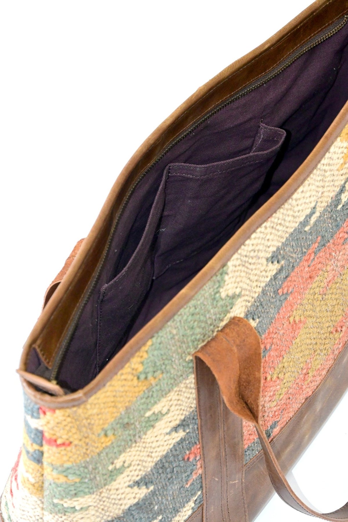 Alpine kilim and leather handbag flat lay — Art Avenue