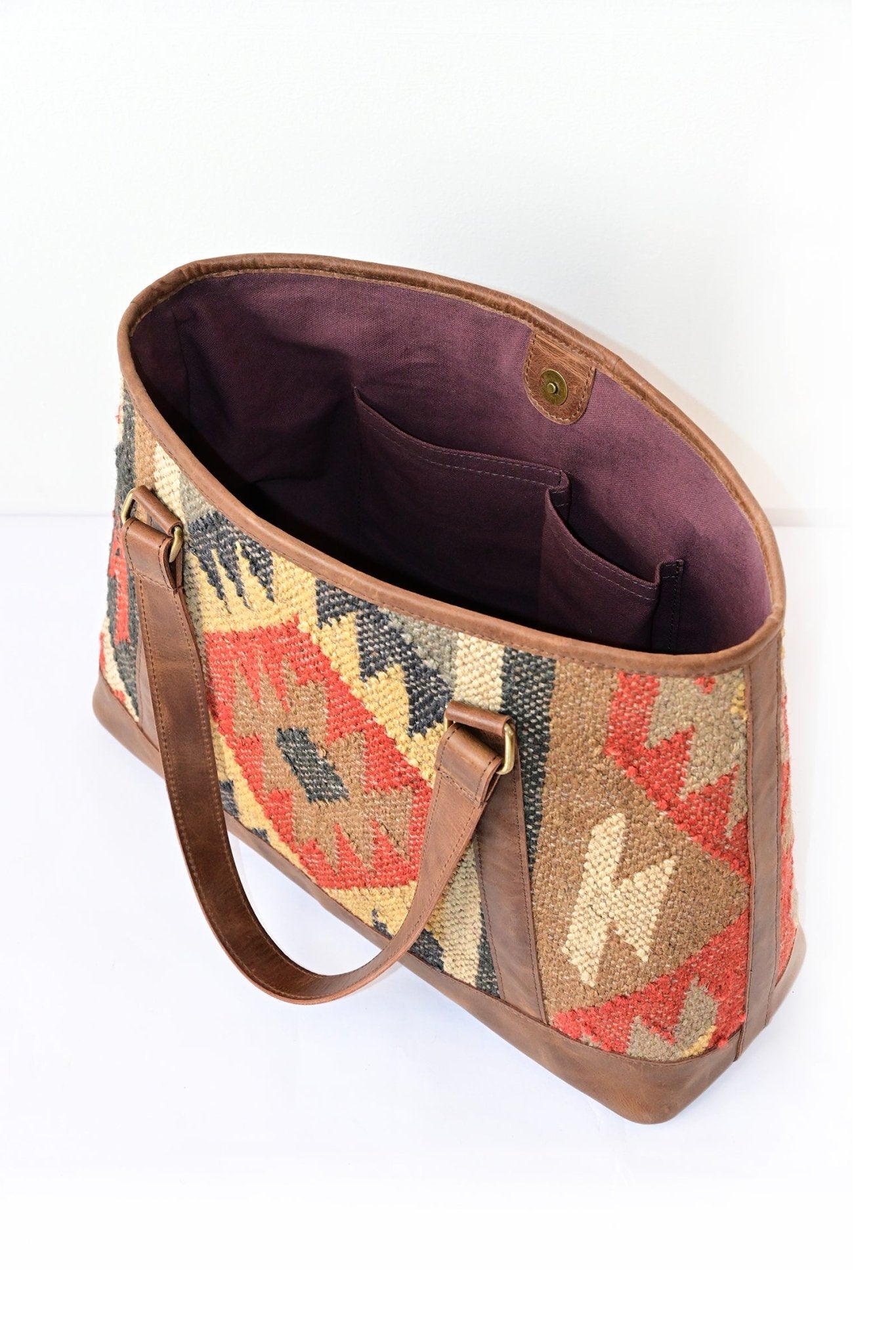 Nymph kilim and leather handbag flat lay — Art Avenue